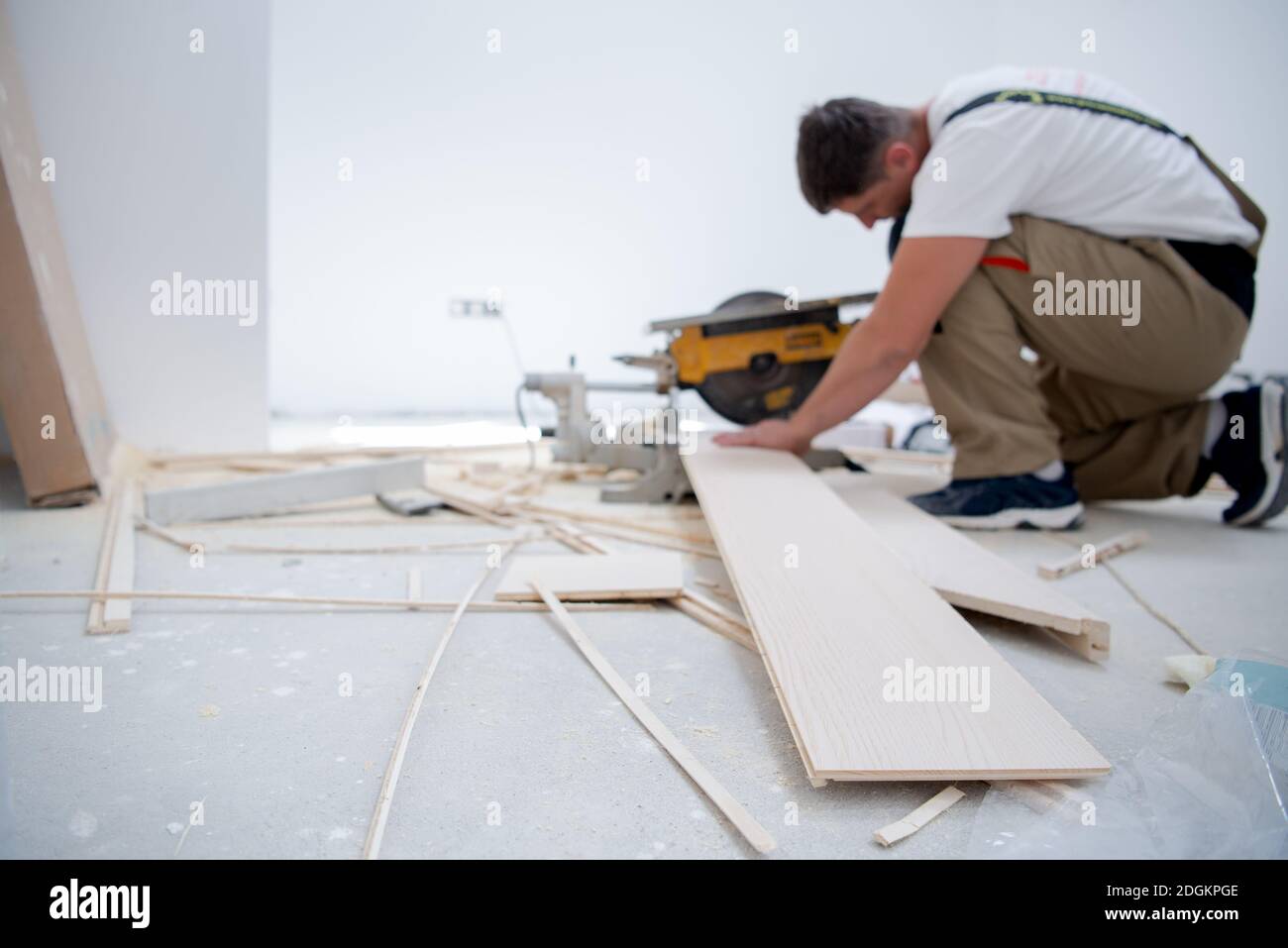 Man cutting laminate floor plank with electrical circular saw Stock