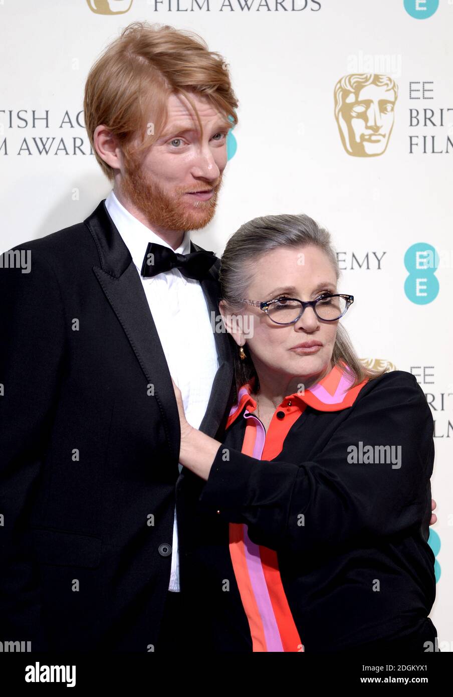 Domhnall Gleeson and Carrie Fisher in the press room during the EE British Academy Film Awards at the Royal Opera House, Bow Street, London.  EMPICS Entertainment Photo. Picture date: Sunday February 14, 2016. Photo credit should read: Doug Peters/ EMPICS Entertainment Stock Photo
