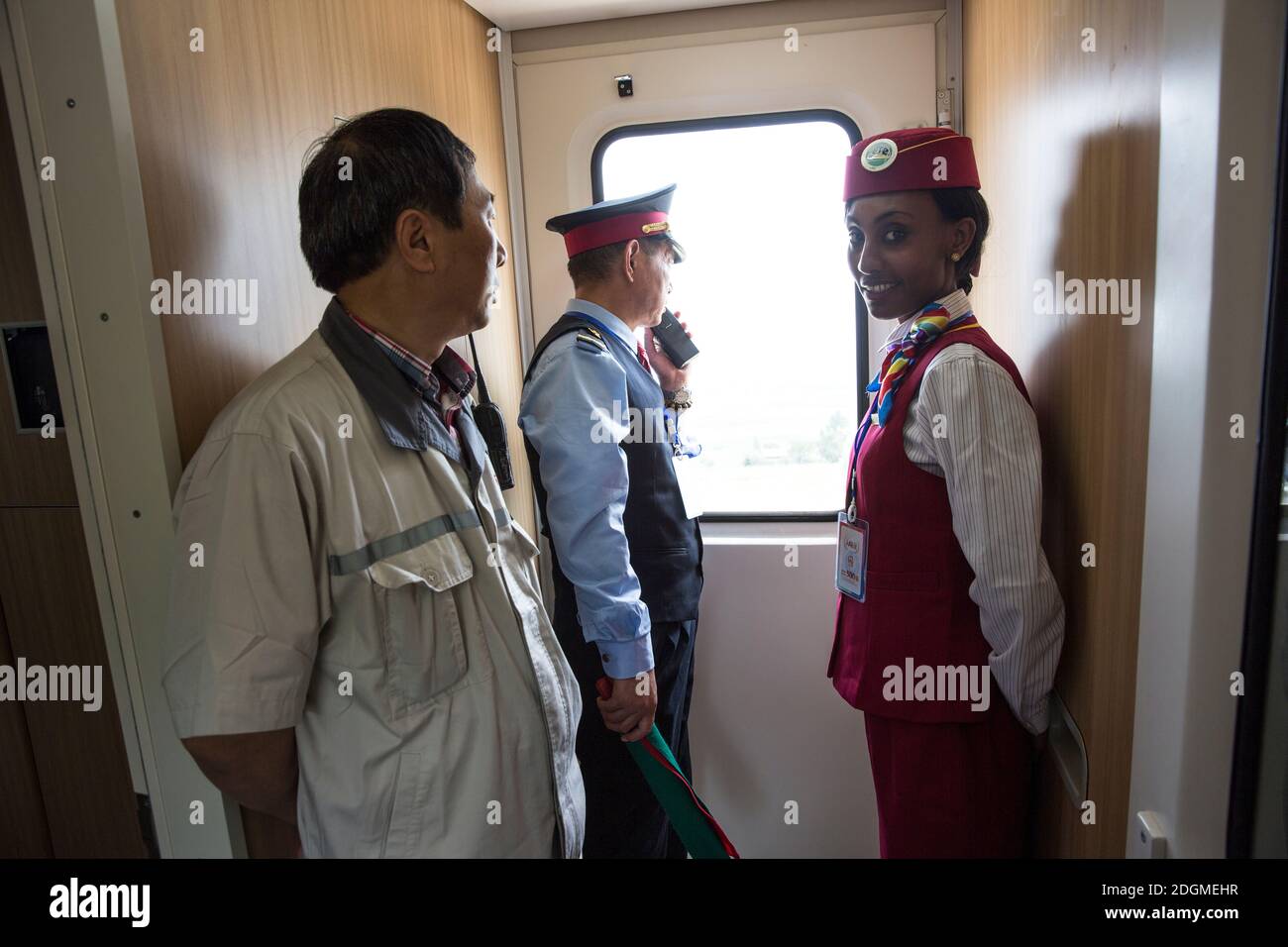 --FILE--An African railway attendant wearing standard uniform of China's high-speed railway attendants serves passengers on a train at a railway stati Stock Photo