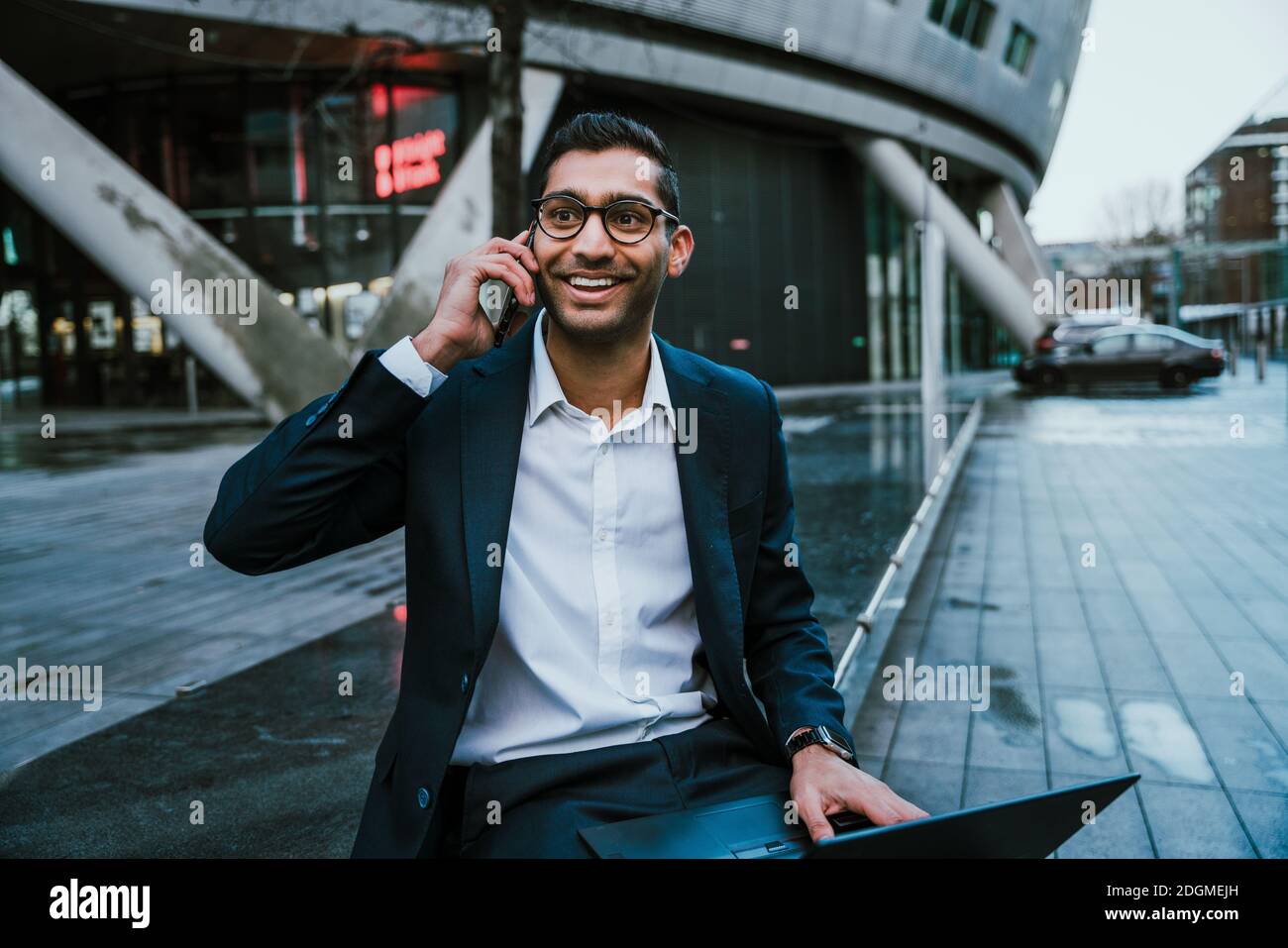 Mixed race businessman chatting on cellular device taking lunch break from work Stock Photo