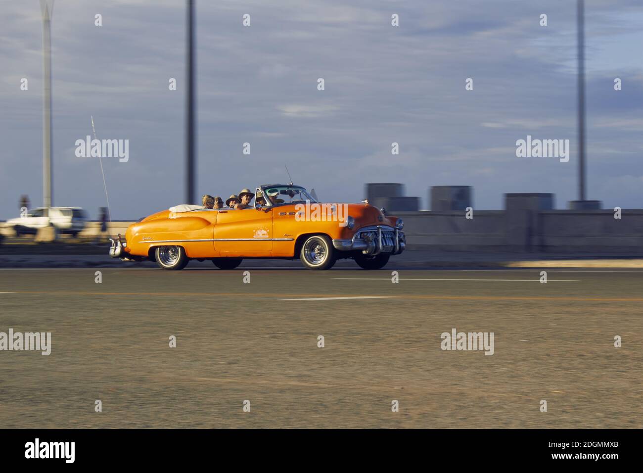 LA HABAN, CUBA - Aug 14, 2019: Auto antiguo anaranjado conduciendo por una calle iluminado por el atardecer. Stock Photo