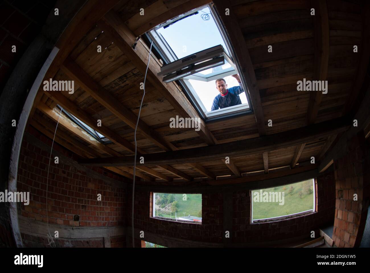 Construction worker installing roof window Stock Photo