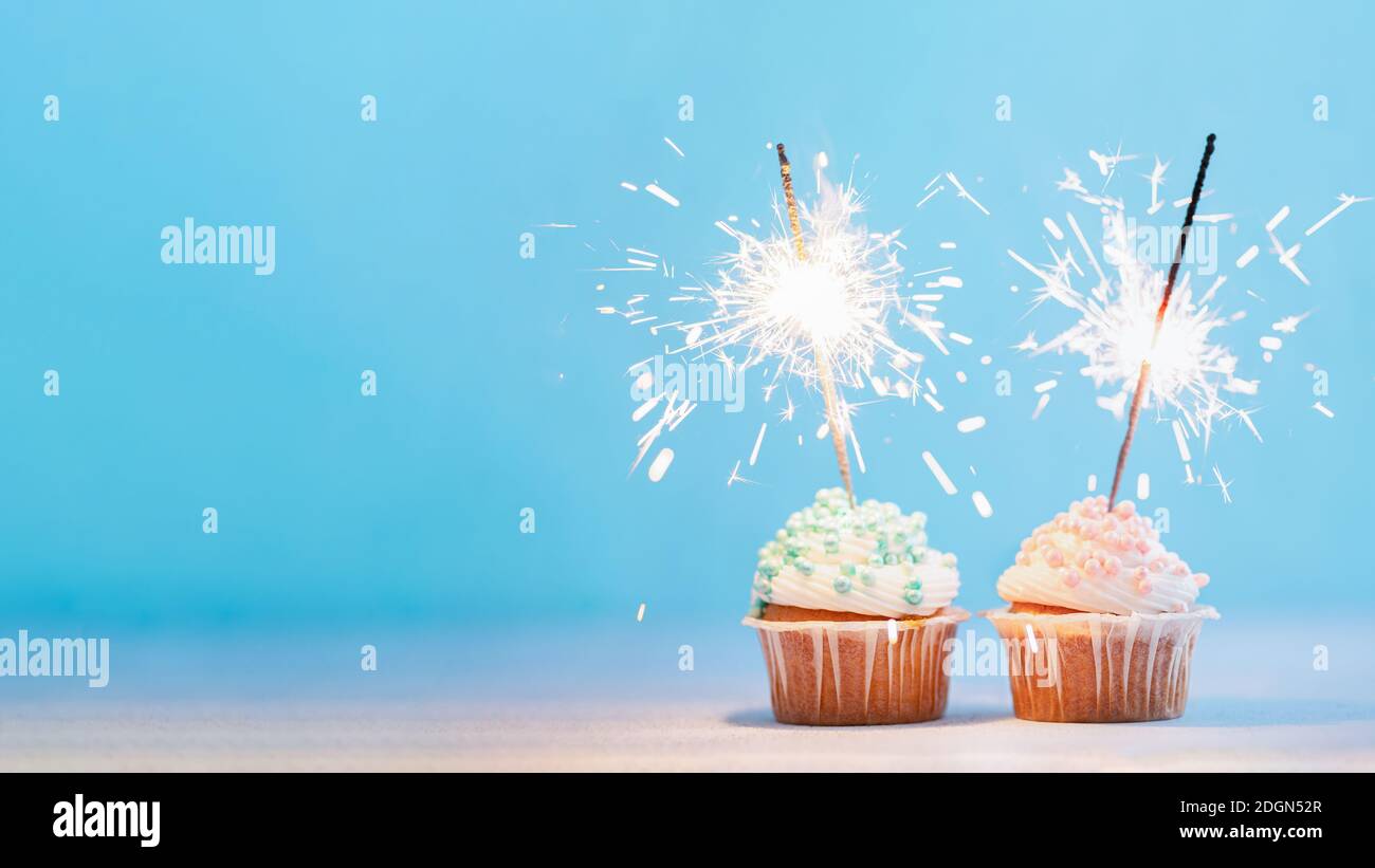 Two cupcakes decorated with sparklers, copy space Stock Photo