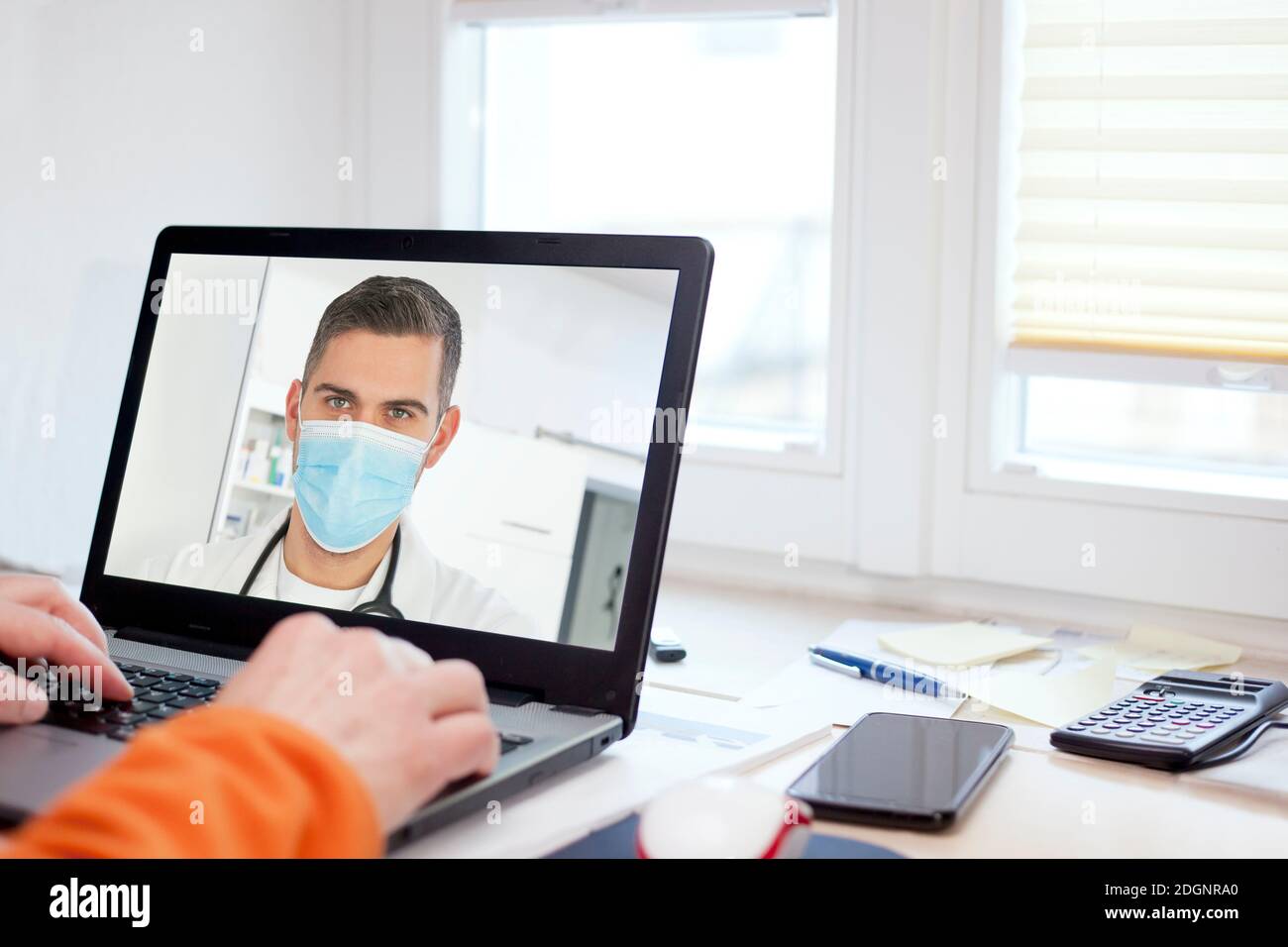 Patient talking online via video call with his doctor - focus on the face of the doctor Stock Photo