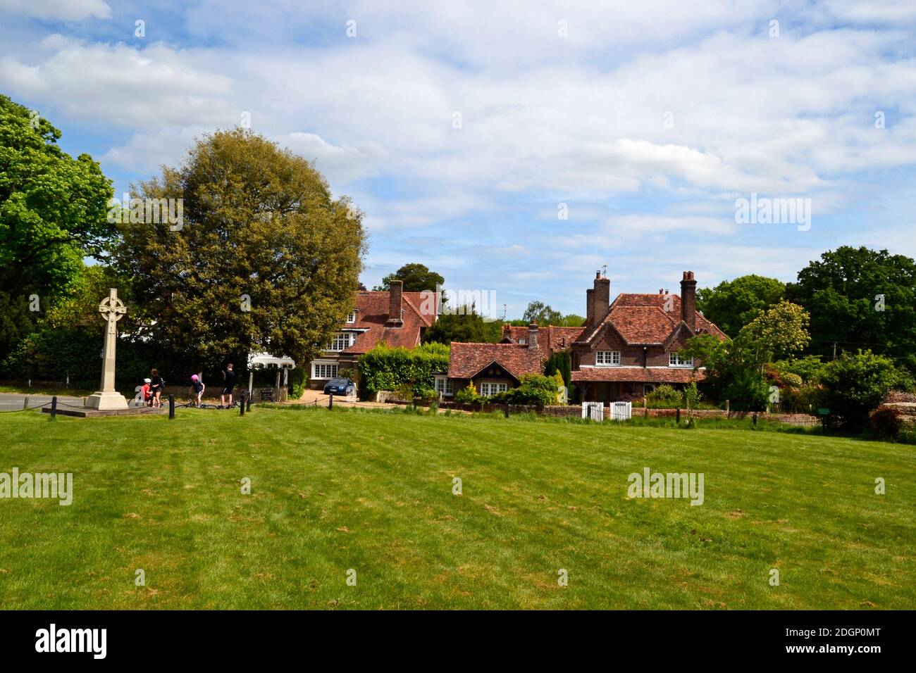 View of cottages and a celtic cross war memorial, on the village green at Lee Common, Buckinghamshire, UK Stock Photo