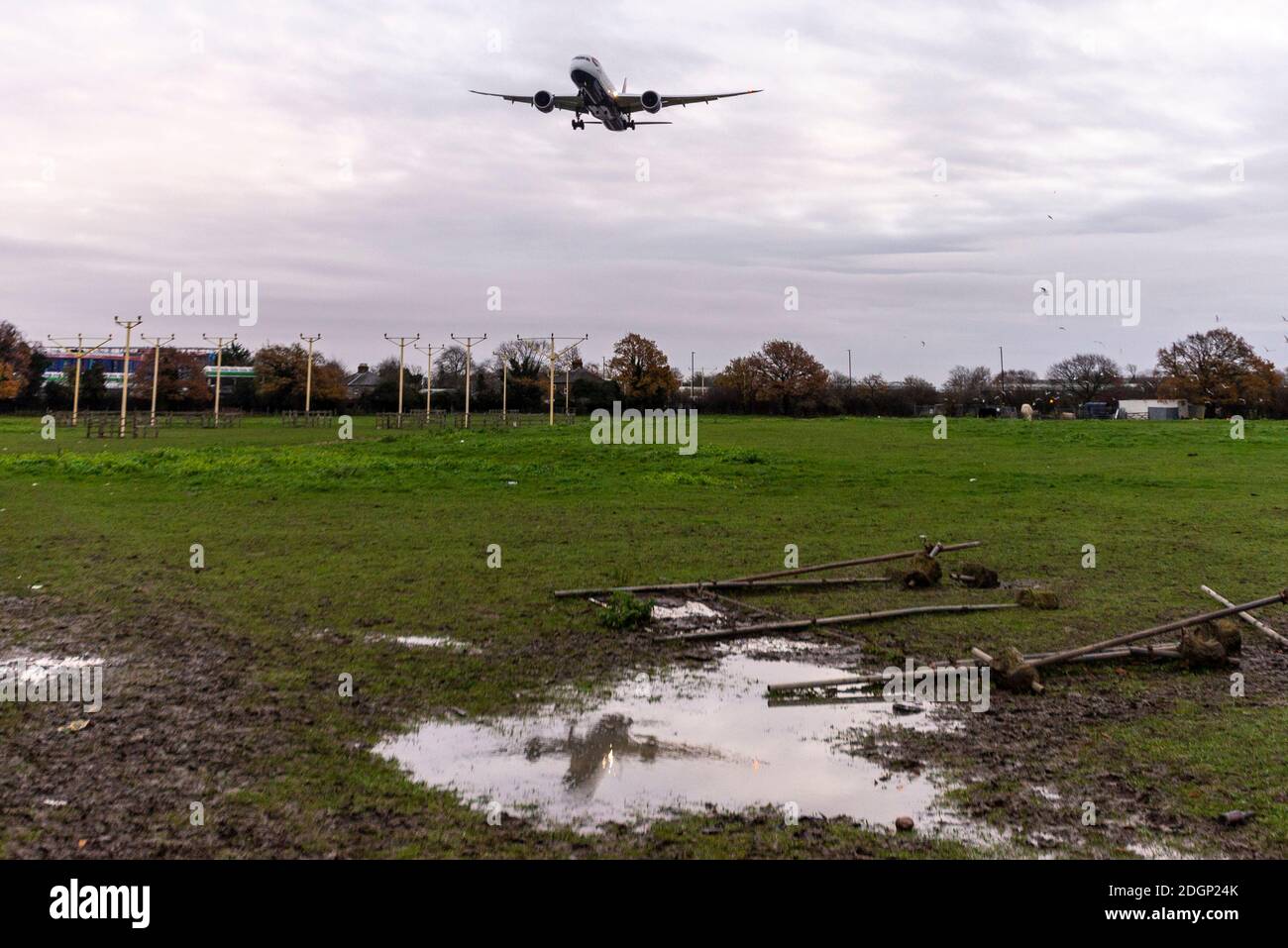 London Heathrow Airport, London, UK. 9th Dec, 2020. Overnight rain has cleared into a cloudy cool morning as the first arrivals land at Heathrow. The rain has left the ground sodden with puddles reflecting the landing aircraft Stock Photo