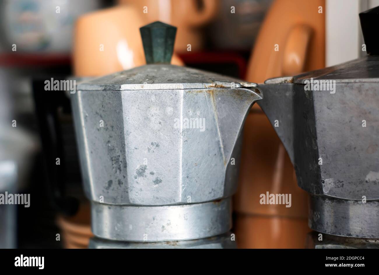 Close-up view of an old rusty coffee pot inside a pantry. Scratches and signs of wear near the spout. Design object. Italian culture Stock Photo