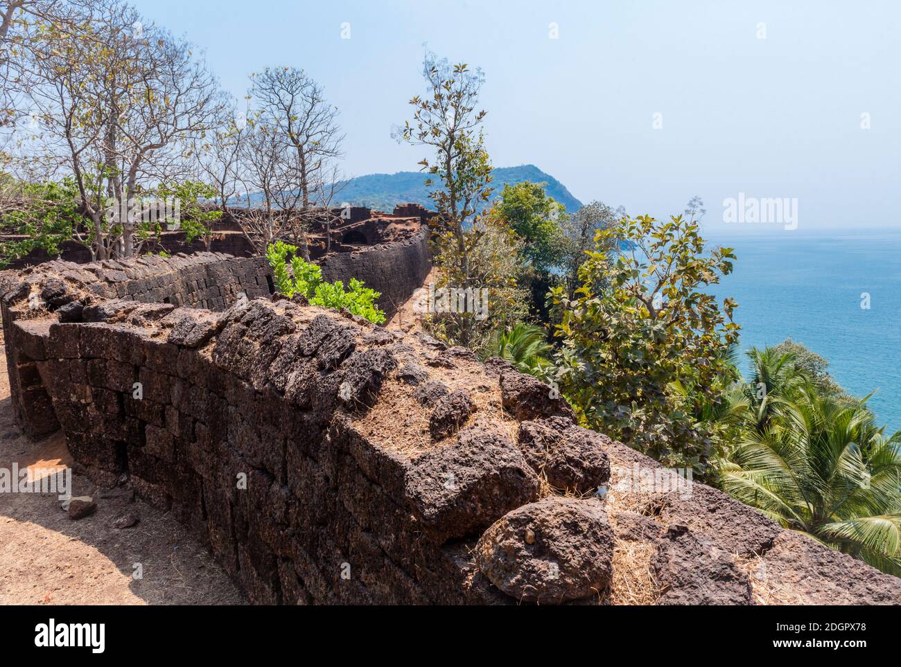 View of the old stone wall of the Portuguese fortress Fort Cabo De Rama, Indian ocean and mountains in Goa, India Stock Photo