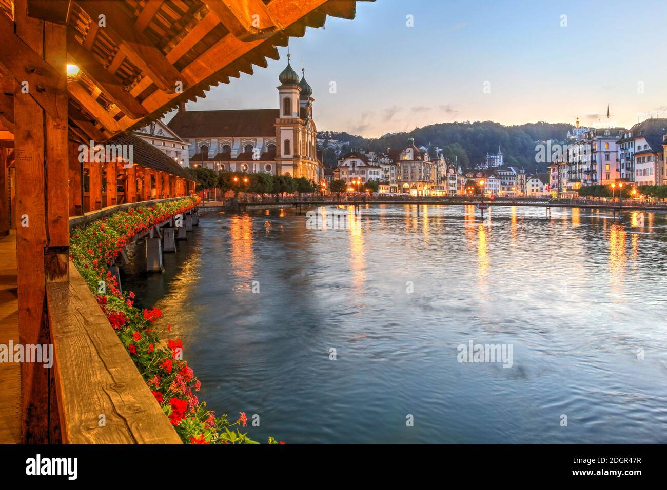 Evening scene from the picturesque Chapel Bridge over the Reuss River with the Luzern Jesuit Church and the riverfront, Lucerne, Switzerland. Stock Photo