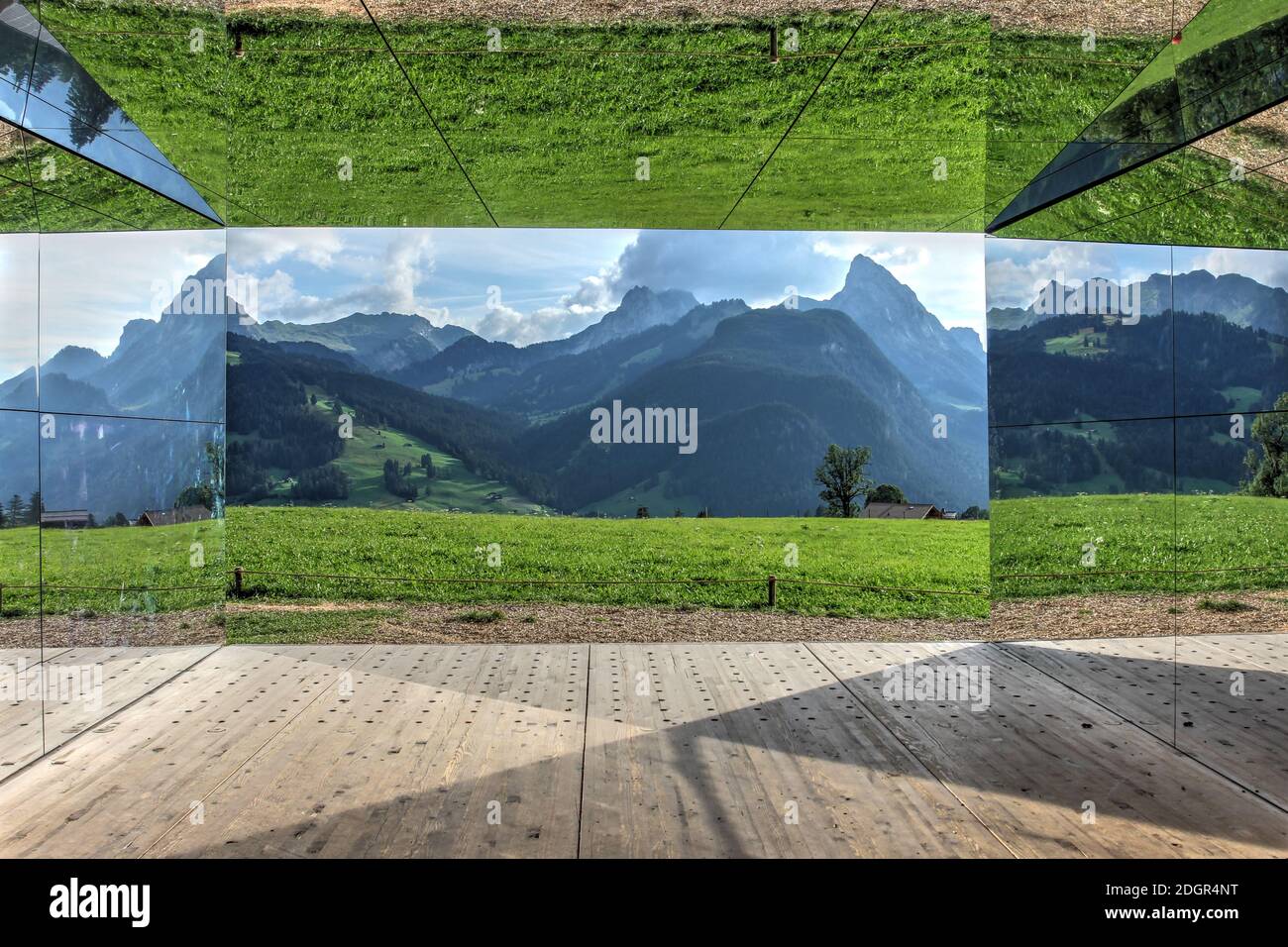 Gstaad, Switzerland - August 15, 2020 - Landscape of the Swiss Alps mirrored by the walls of the Mirage, temporary art instalation by Doug Aitken cons Stock Photo