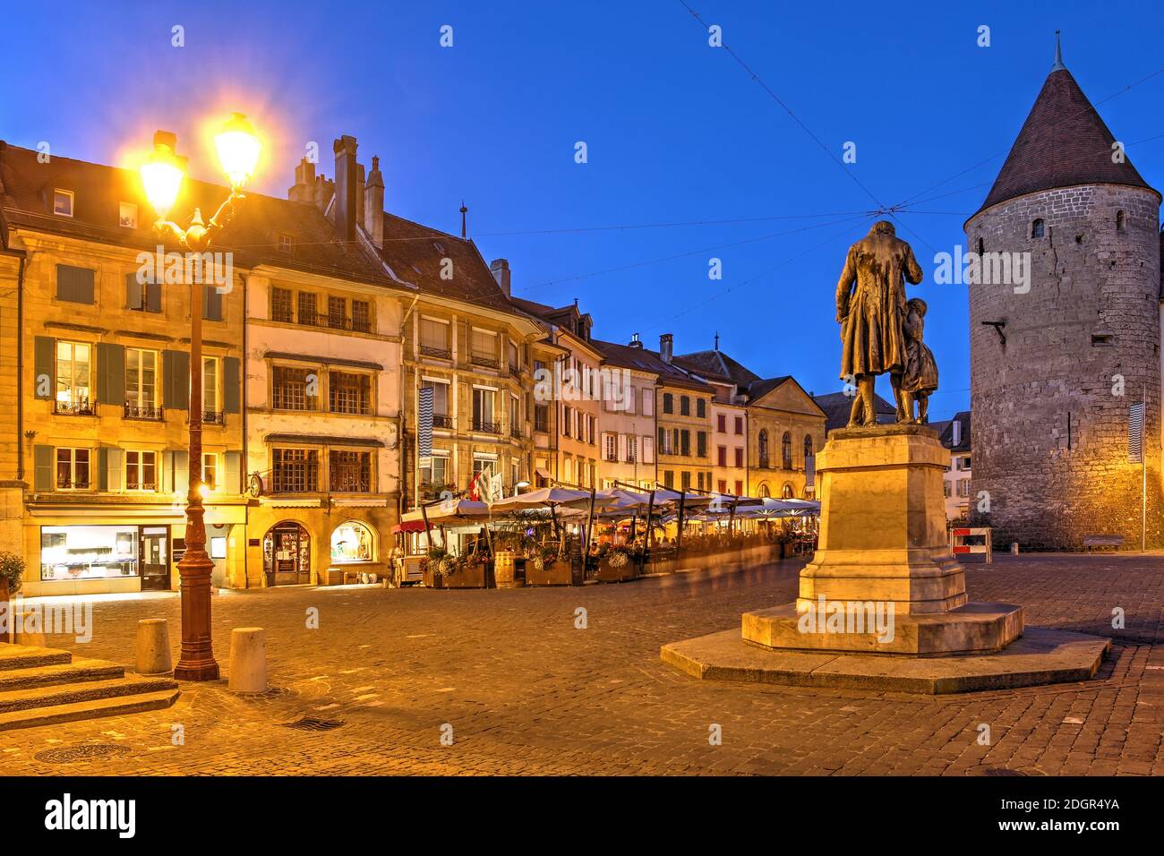 Night scene in Pestalozzi Square in Yverdon les Bains, Switzerland with his statue, a row of historical houses and Chateau d'Yverdon. Stock Photo