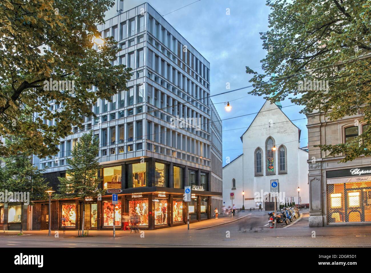 Night scene from Bahnhofstrasse, the main shopping street of Zurich featuring the Prada store and the Augustinerkirche, one of the oldest churches in Stock Photo