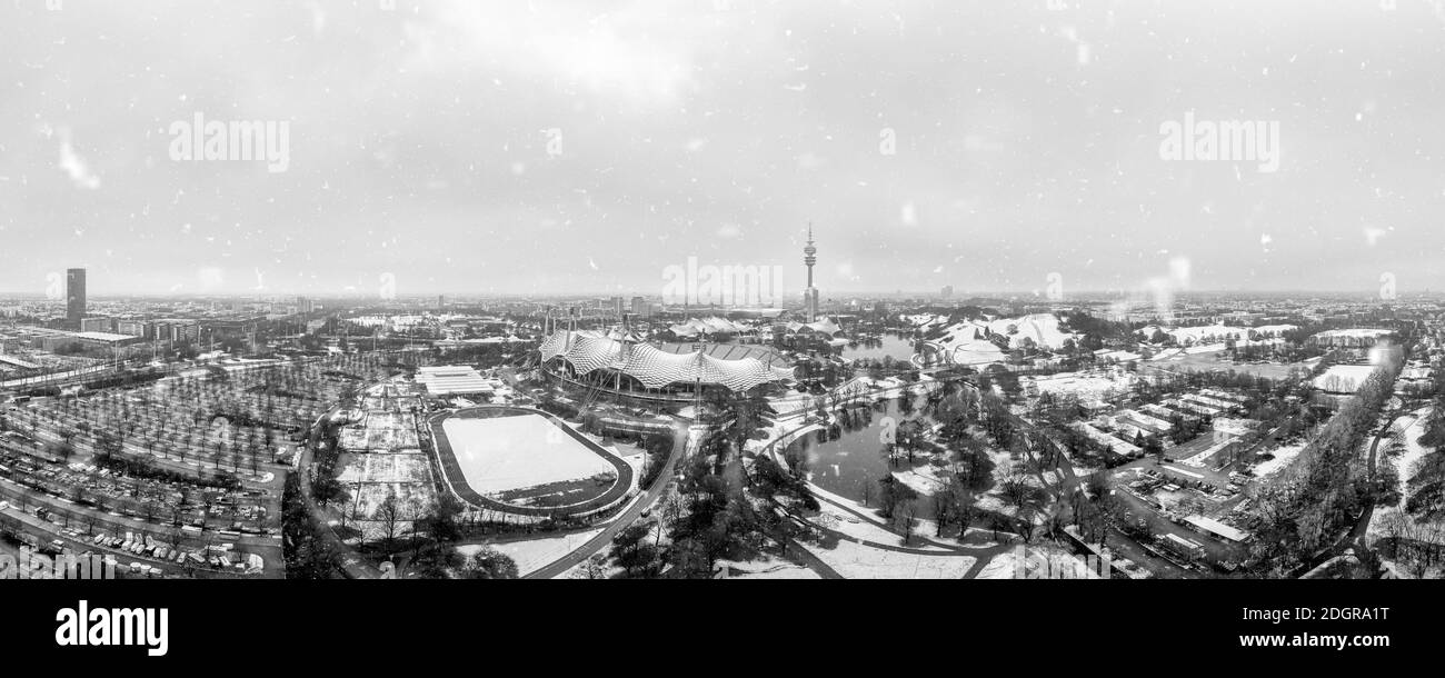 Snowflakes over Munich, the bavarian city in winter with the panoramic view over the Olympic Park, snow covered. Stock Photo