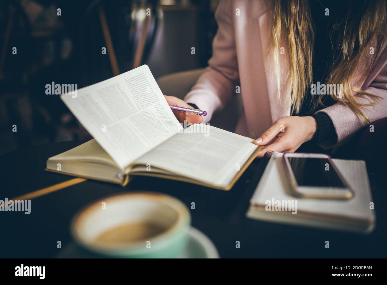 Business, education concept. Woman working in outdoor at coffee shop. Close up caucasian woman hand on wooden table inside cafe Stock Photo