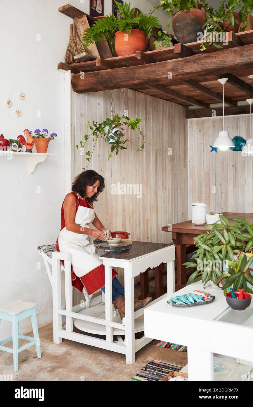 Elsa working at the wheel in her pottery studio in the village of Aljezur, Western Algarve. Stock Photo