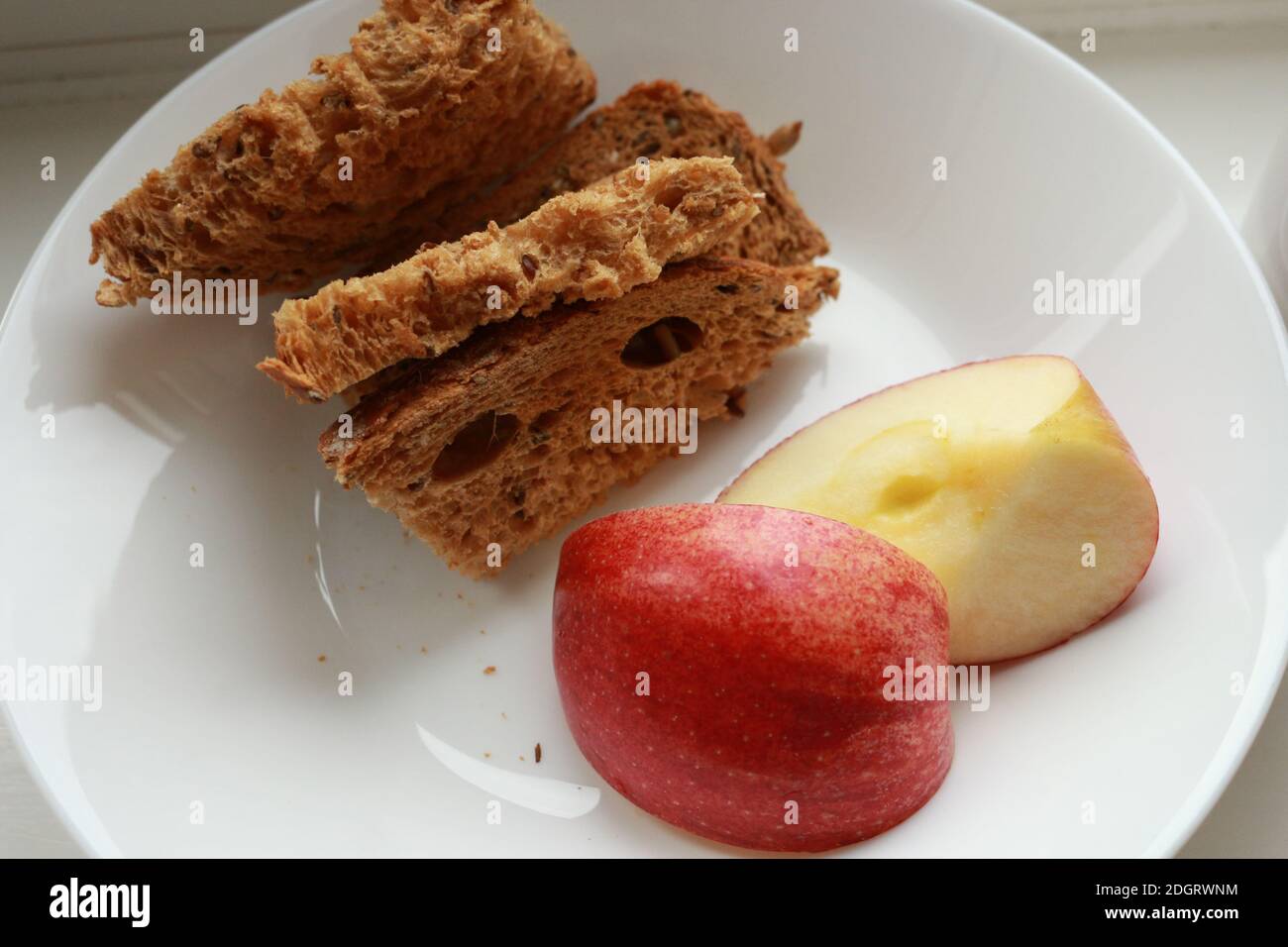 Low glycaemic index Breakfast Brown Bread with slice of apples on white plate Stock Photo