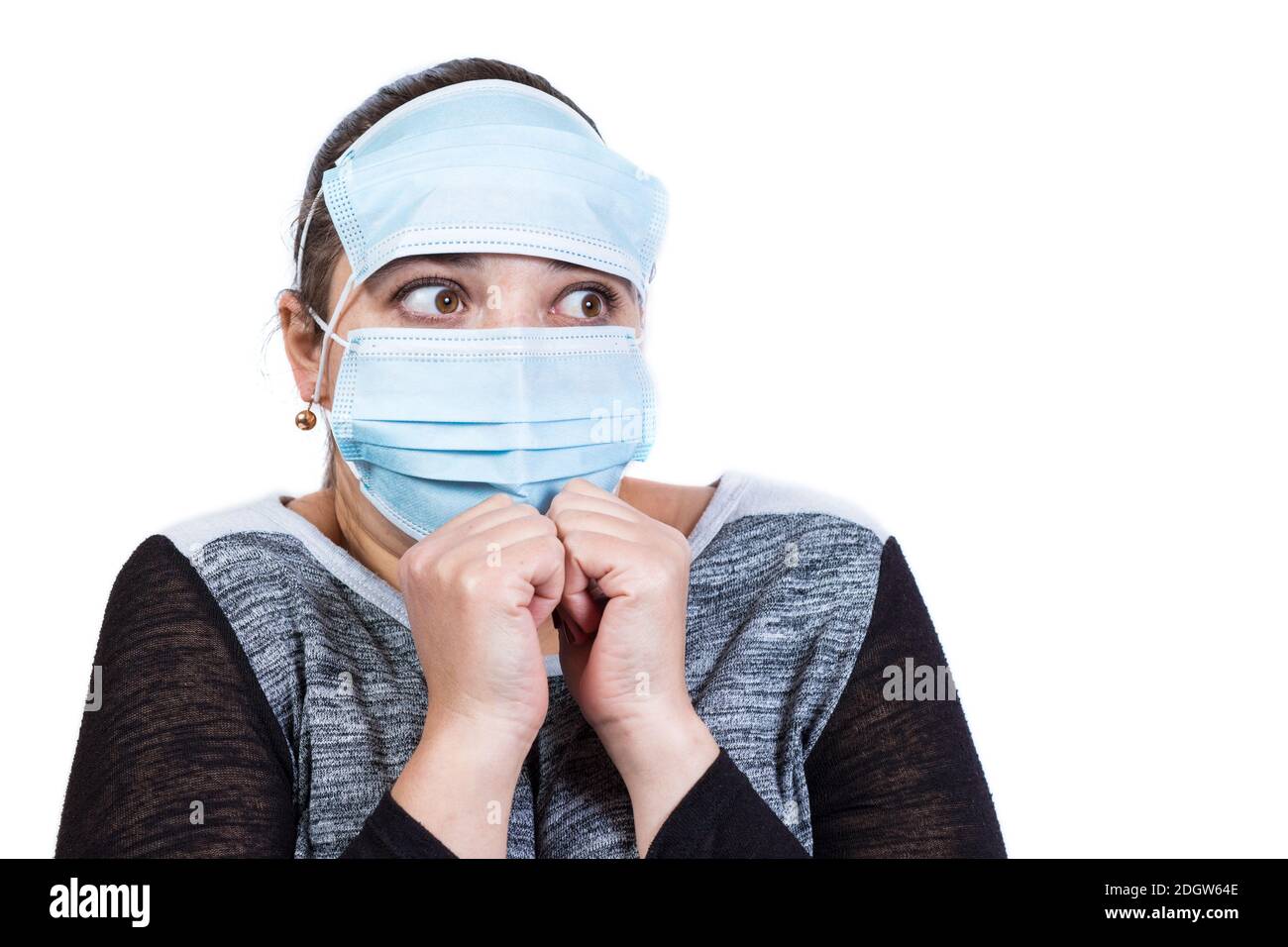 Funny scared face of young girl in medical mask isolated on a white. Stock Photo