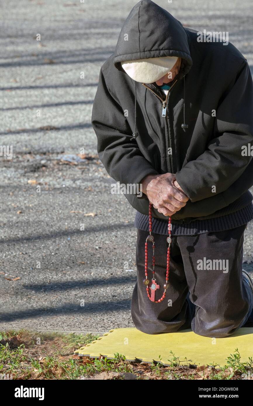 A devout Roman Catholic man prays at the Vatican Pavilion site in Flushing Meadows park where Mary & Jesus appeared to Veronica Lueken. In NYC. Stock Photo