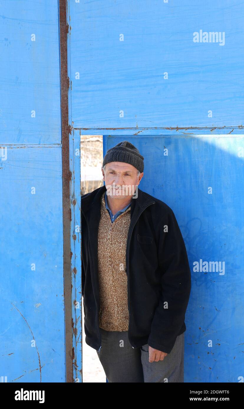 NIGDE,TURKEY-JANUARY 15:Unidentified Man coming out from Metal Blue Door.January 15,2017 in Nigde,Turkey. Stock Photo