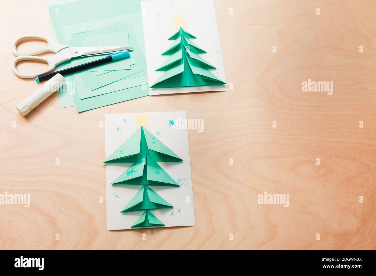 Two greeting cards for Christmas made by the hands of adult and child. Xmas tree upside down, strange Christmas 2020, new normal concept. Stock Photo