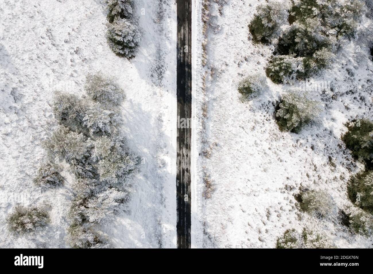 Aerial view of empty snow covered road in winter forest. High quality ...