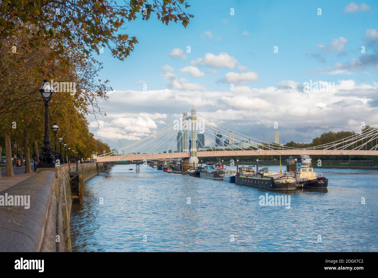 London, Chelsea. Cadogan Pier - a river Thames mooring used by Thames Clippers, river and houseboats, Albert Bridge, Thames path at Cheyne Walk Stock Photo