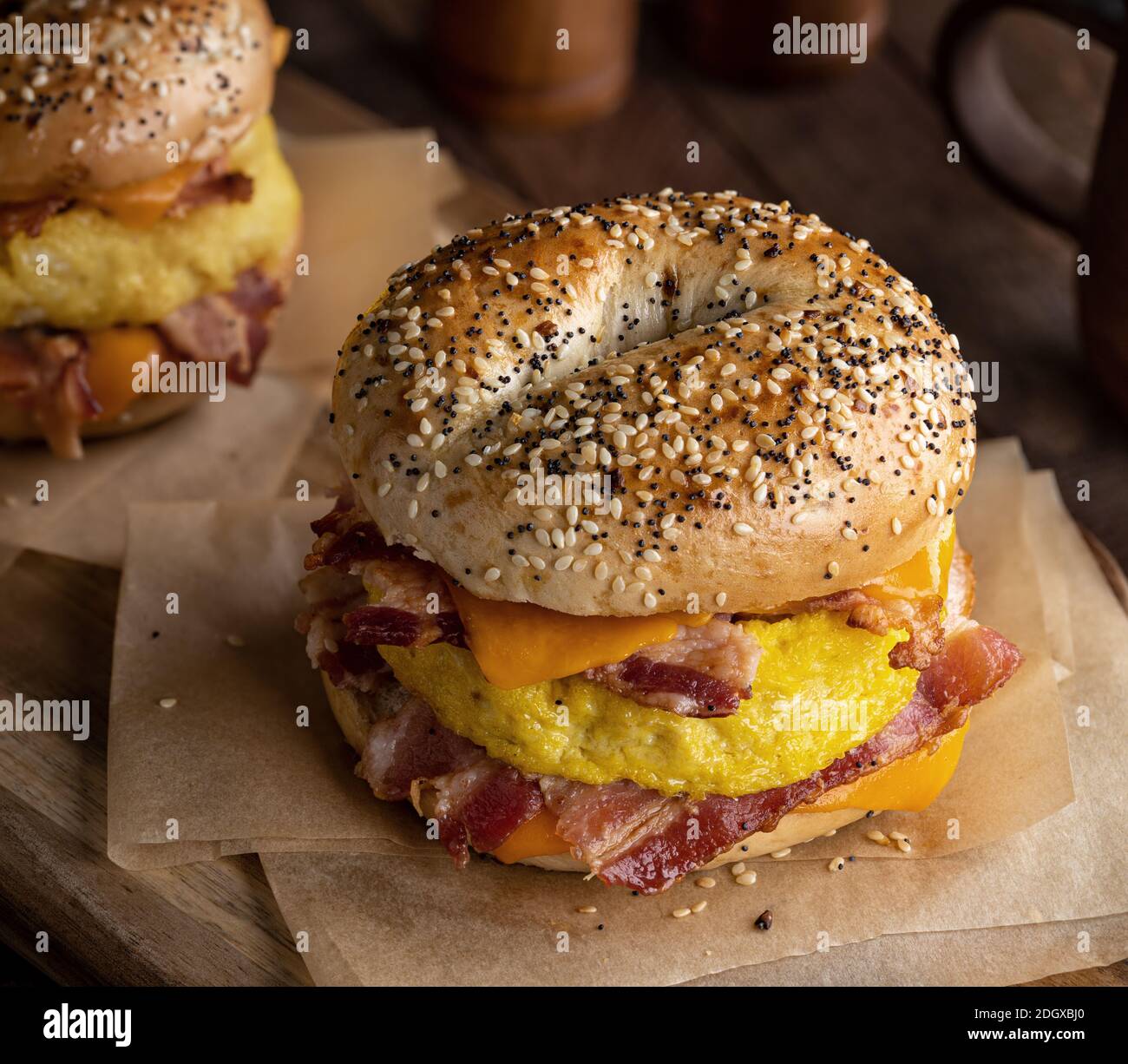 Bagel breakfast sandwich with bacon, egg and cheddar cheese on a rustic ...