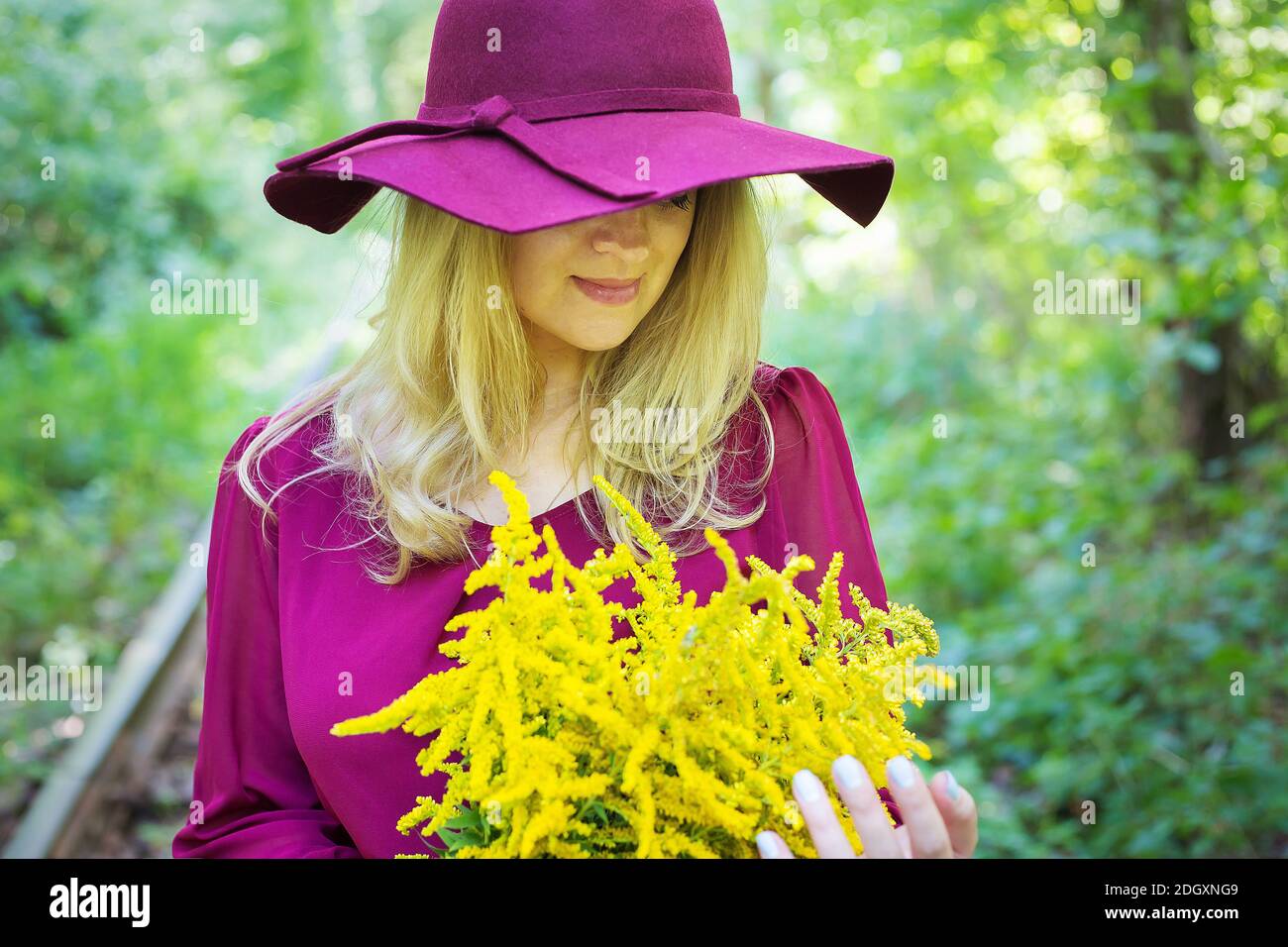 girl in a hat with a bouquet of yellow flowers Stock Photo - Alamy