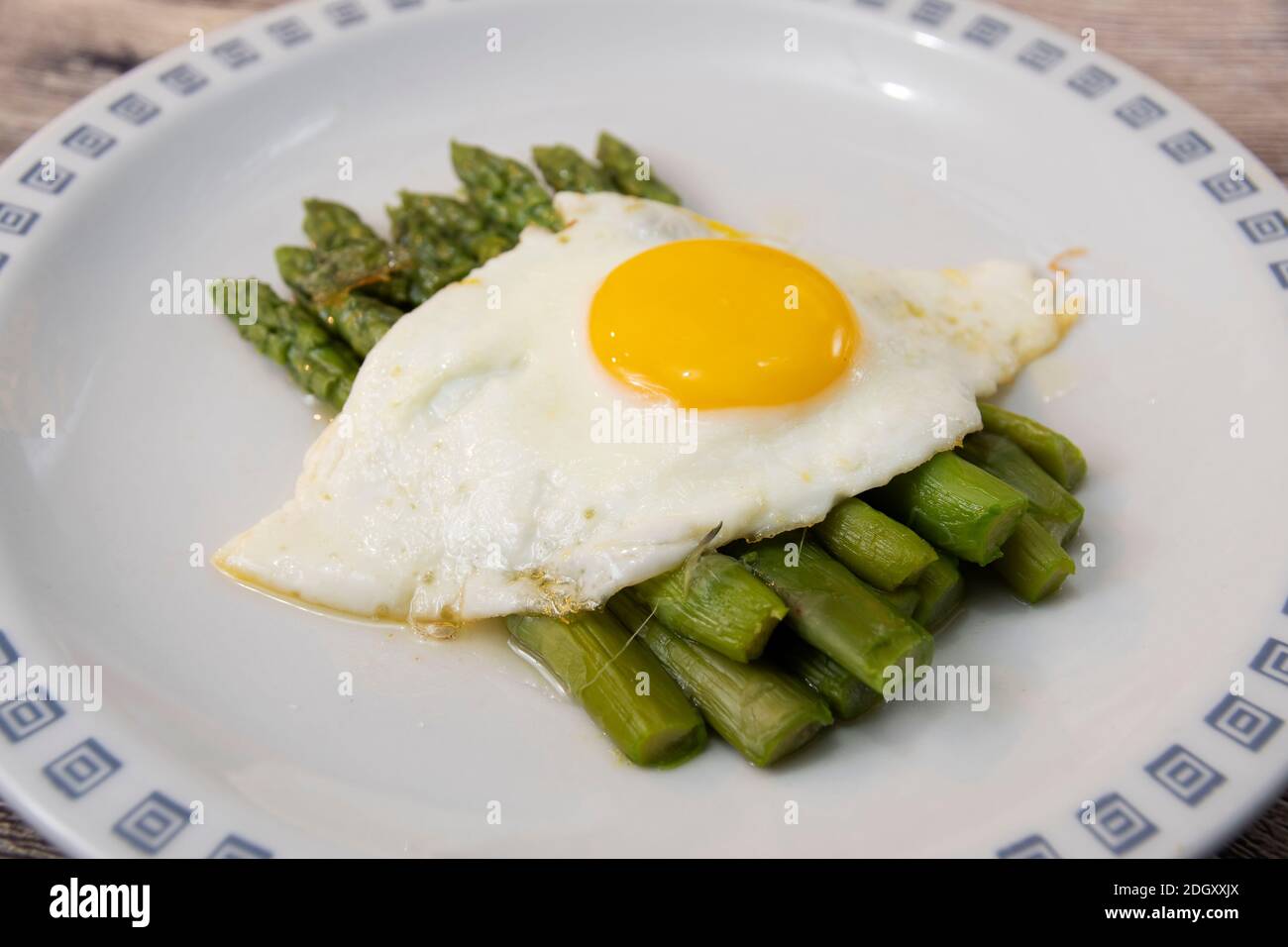 Fried egg with asparagus. Milanese traditional dish Stock Photo Alamy