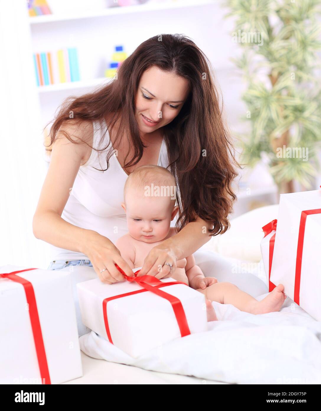 happy mom with her baby opening a gift box Stock Photo Alamy
