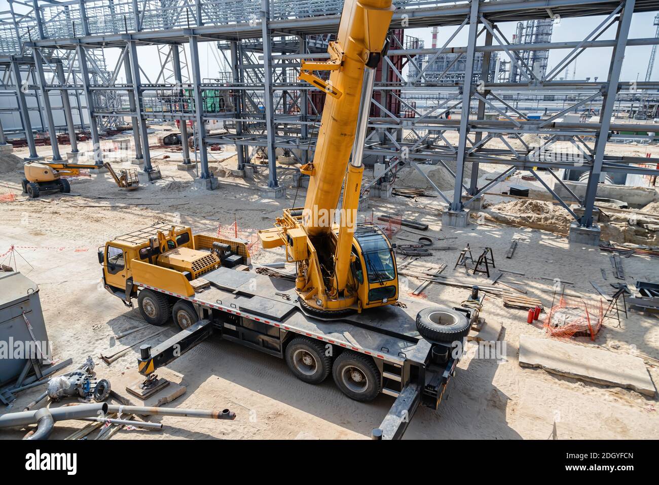 A large yellow car crane stands on the construction site Stock Photo