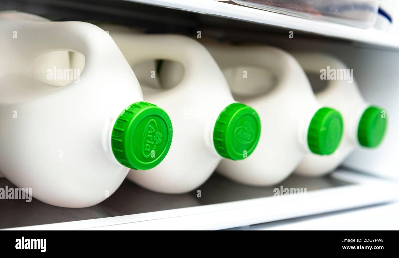 four 2 litre plastic bottles of ARLA milk on a domestic refrigerator shelf Stock Photo