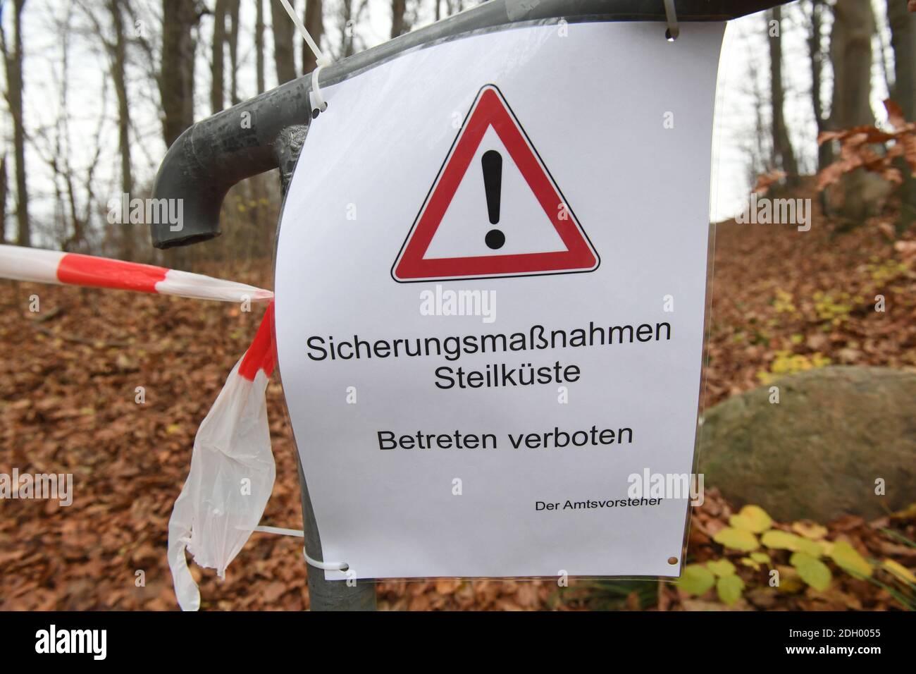 09 December 2020, Mecklenburg-Western Pomerania, Sellin: A sign with the inscription "Sicherungsmaßnahmen Steilküste" (safety measures for steep coast) hangs on a railing. On the steep coast of Sellin on the island of Rügen two excavators are busy demolishing an old NVA bunker on the same day. The 300 square metre GDR bunker, made of one metre wide concrete walls, had been built in 1959. Until 1988 it had been part of the Technical Brigade Coast on the island of Rügen and was part of the radio and airspace surveillance in the Baltic Sea area. The cost of the demolition work is currently estima Stock Photo