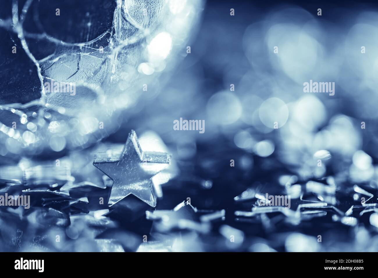 Macro photo of bright silver star and cracked glass sphere Stock Photo