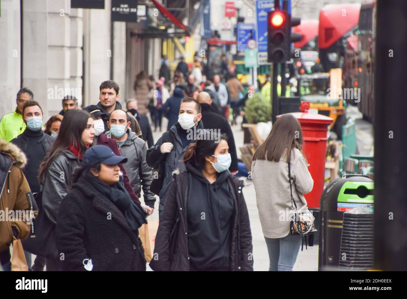 People with protective face masks walking on Regent Street, London