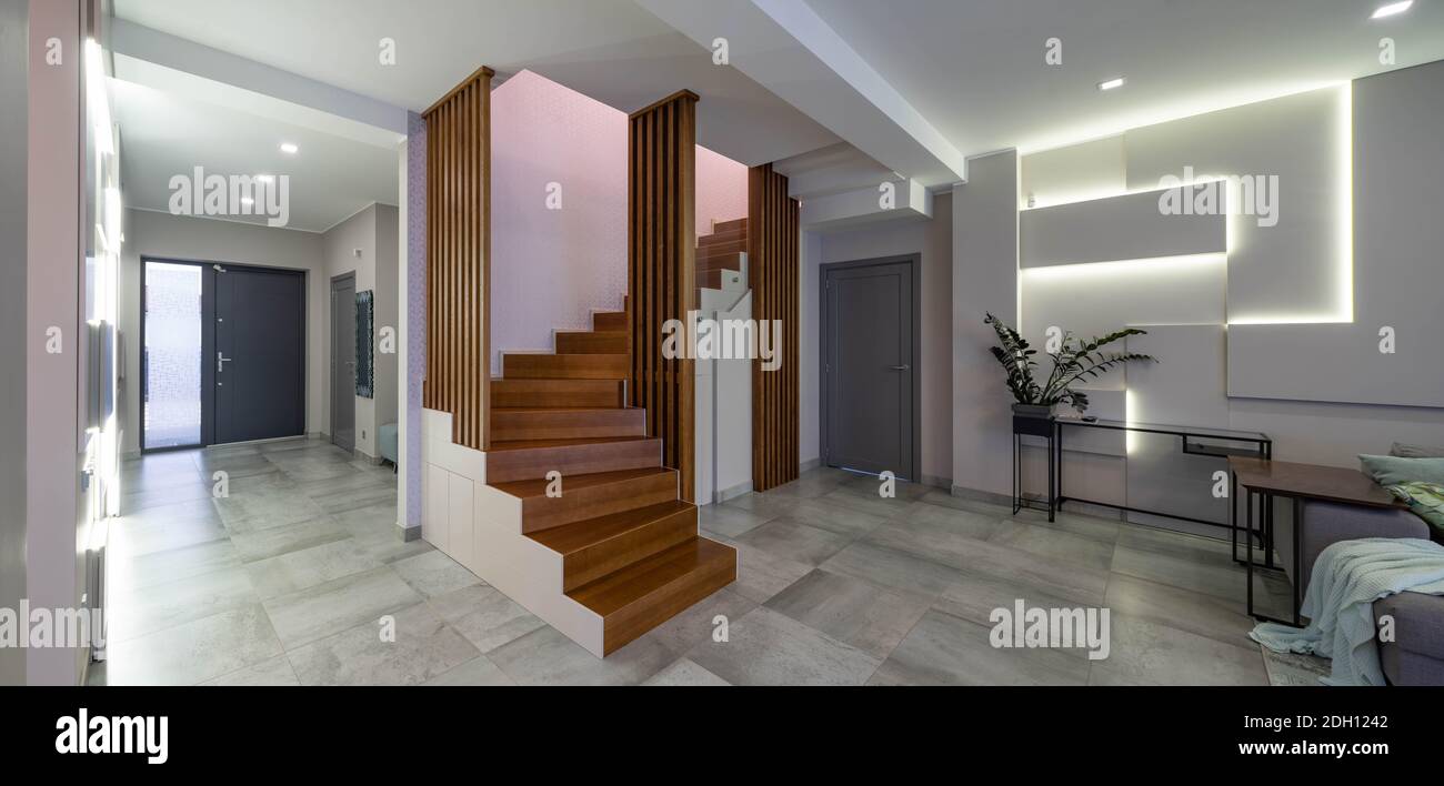 Contemporary interior of luxury flat. Hi-tech design of wall with lamps.  Wooden staircase. Home decor Stock Photo - Alamy