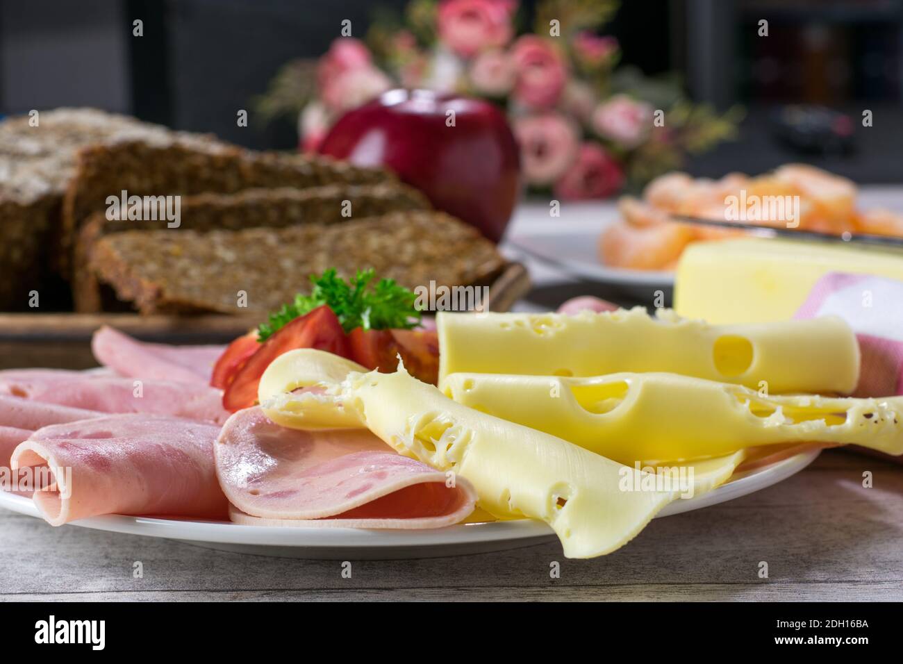 a Plate of cold cuts from Germany with sausage, ham, cheese and rye bread served on a kitchen table - Brotzeit - Abendbrot Stock Photo