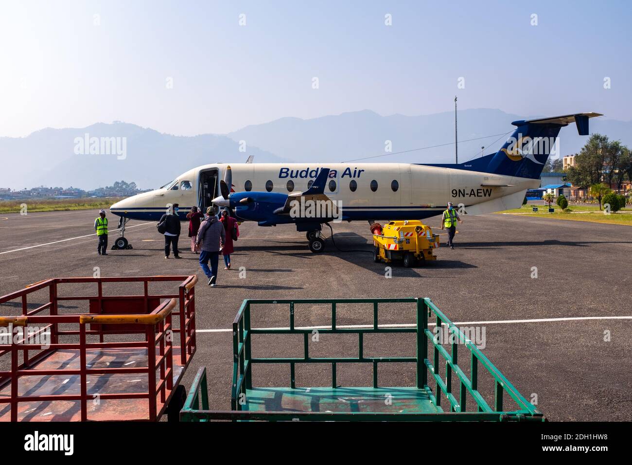 Passengers boarding a Buddha Air B1900D aircraft at Pokhara Airport in Nepal where air travel resumed in September.. Stock Photo