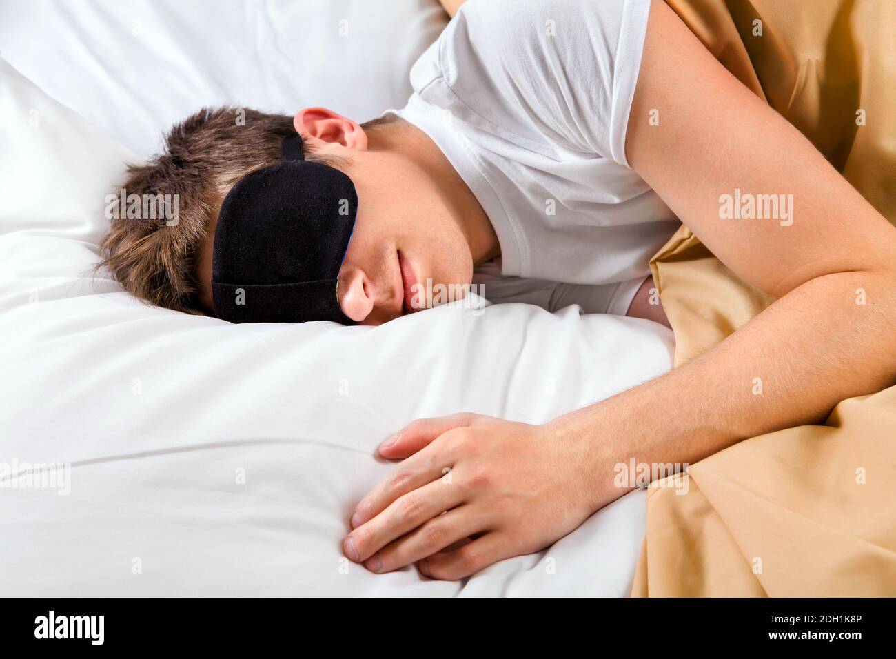 Tired Young Man sleep in the Bed at the Home Stock Photo