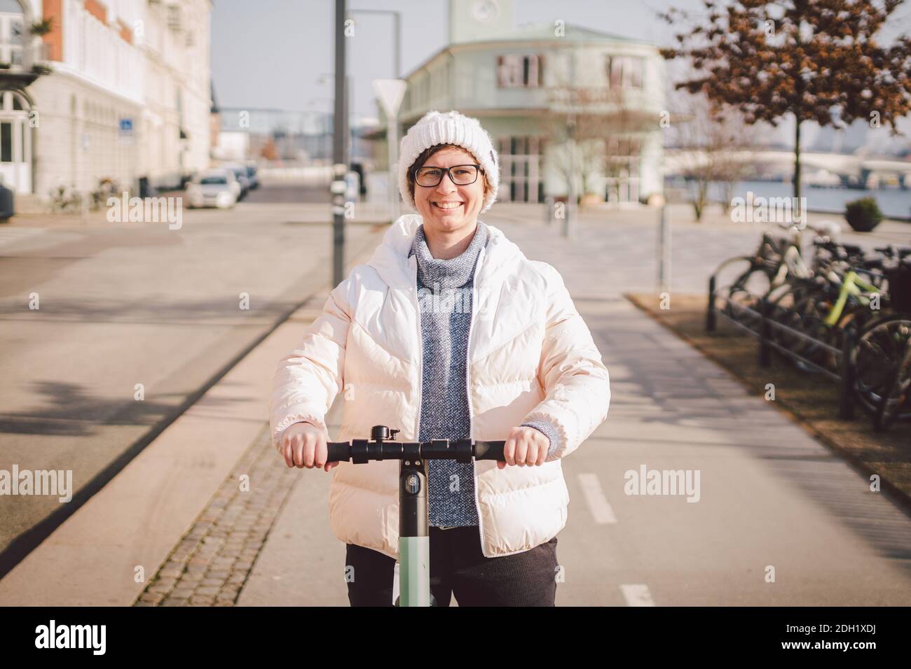Young woman riding an electric scooter on bike path in copenhagen