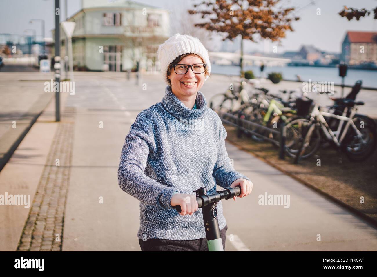 Young woman riding an electric scooter on bike path in copenhagen