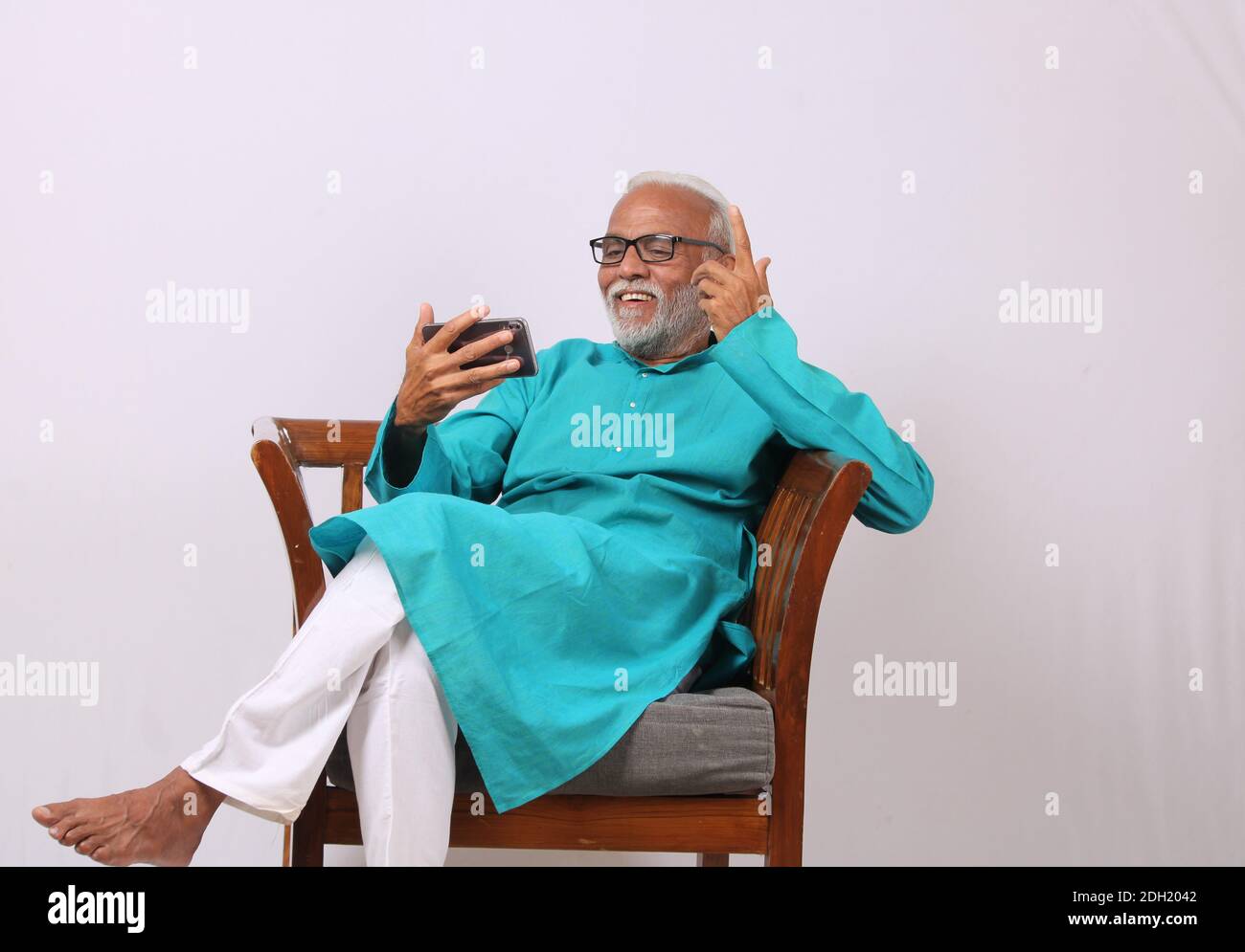 Cool bearded indian old man using mobile phone Stock Photo