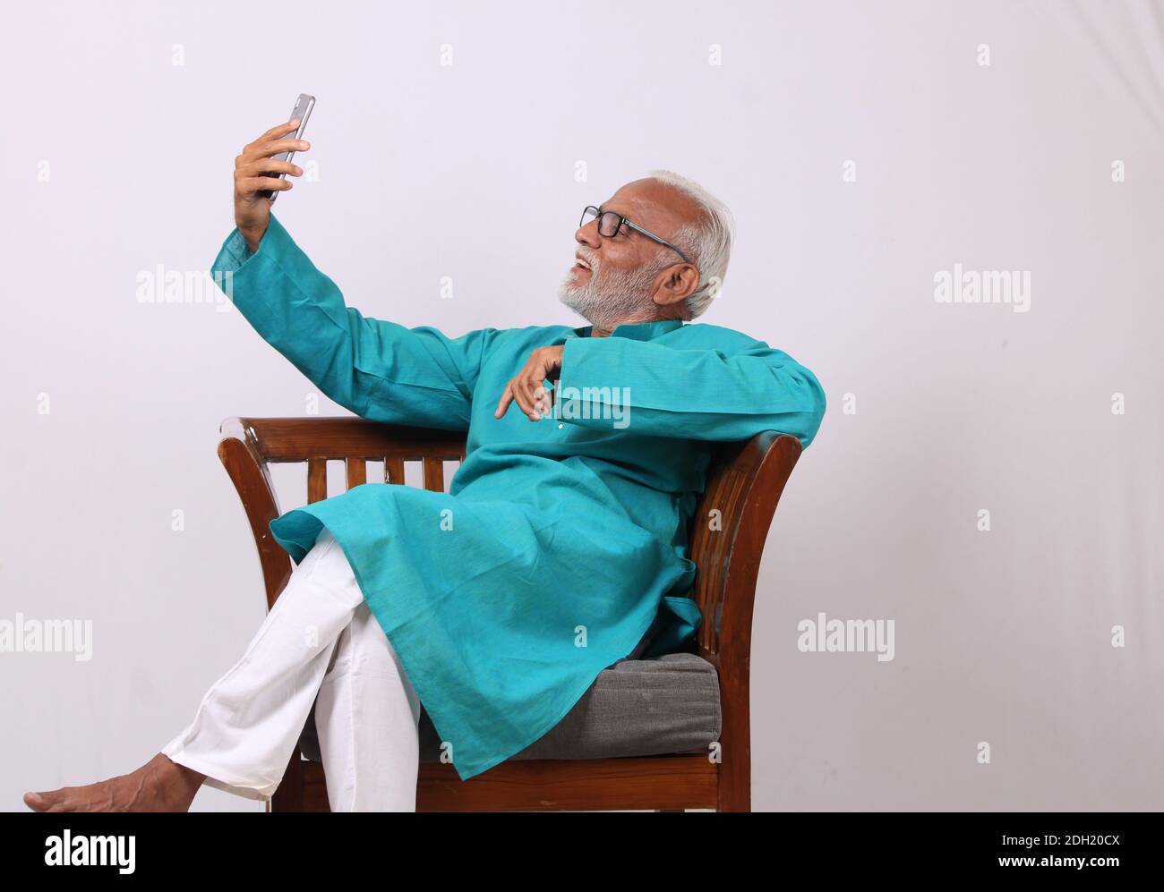 Cool bearded indian old man using mobile phone Stock Photo