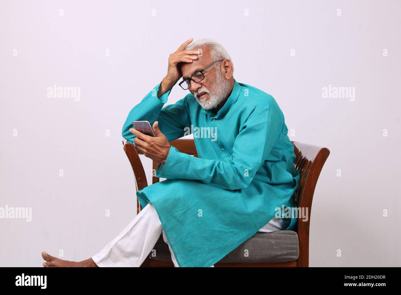 Cool bearded indian old man using mobile phone Stock Photo