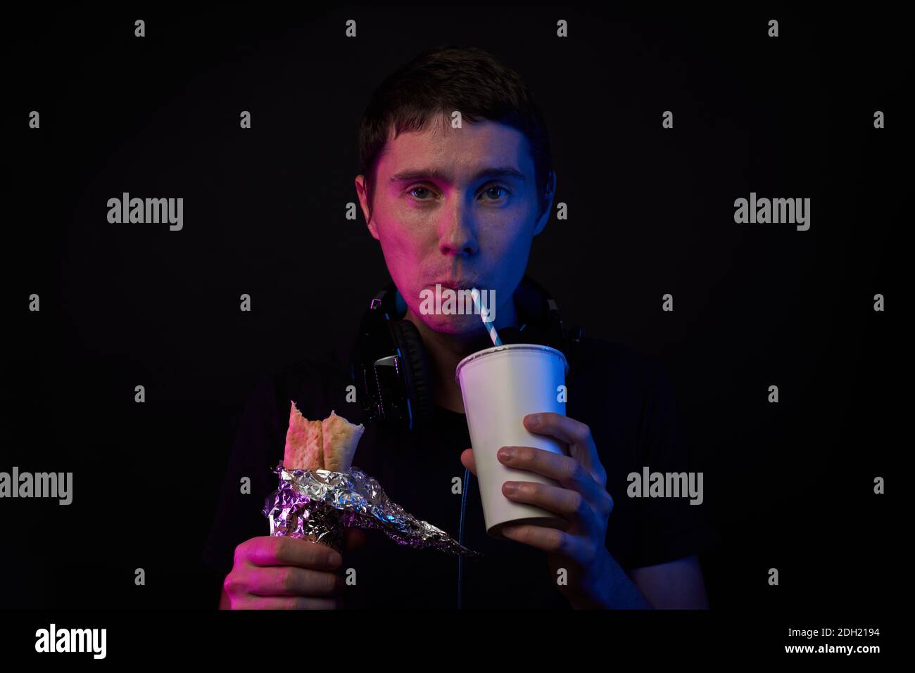 Gamer is eating fast food and drinking cola. Concept of virtual reality