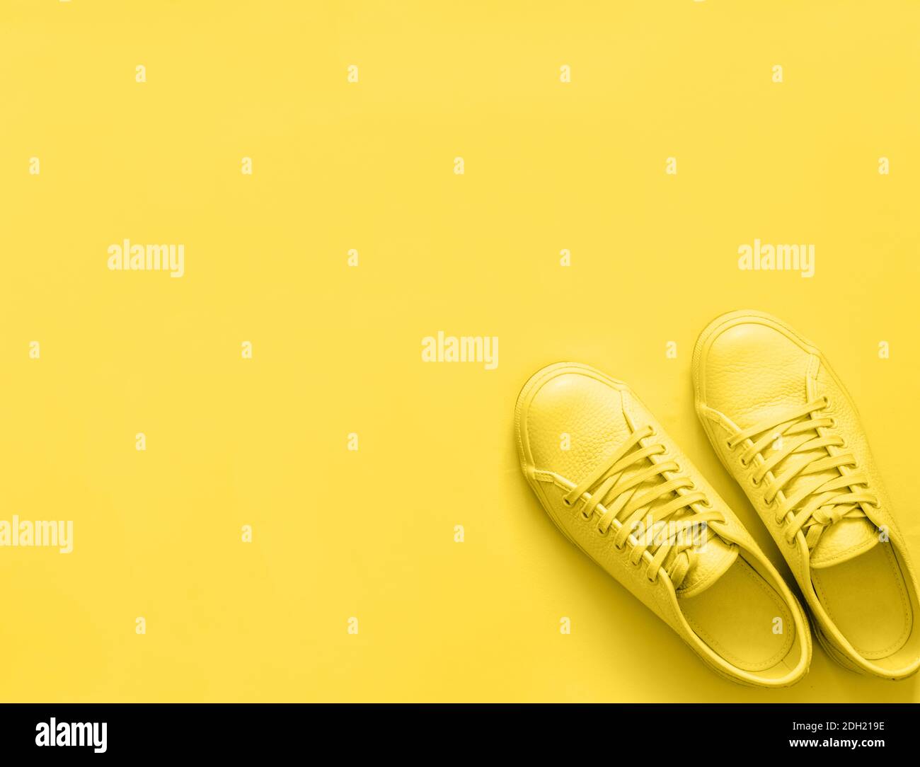 Yellow sneakers on yellow background, copy space Stock Photo