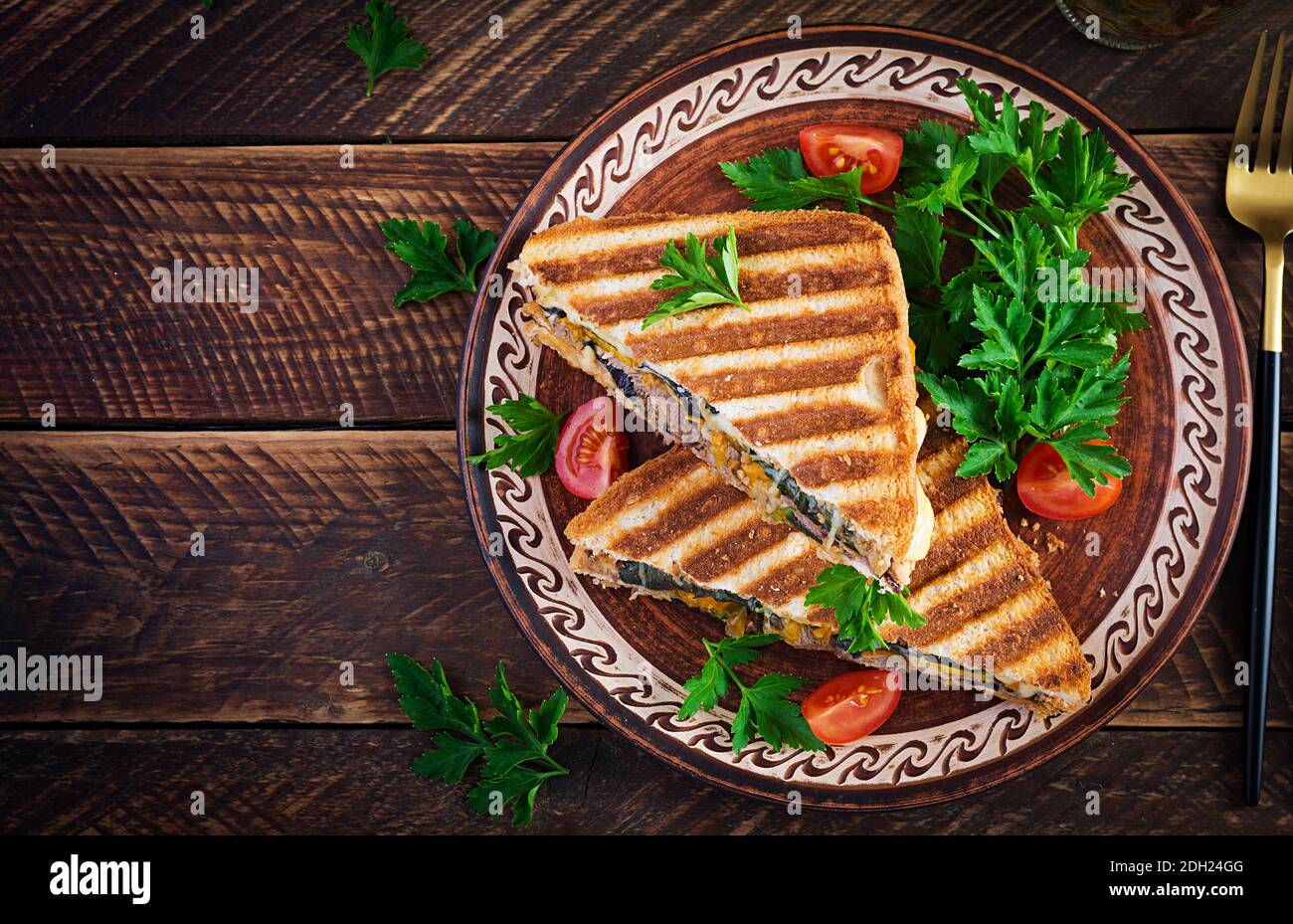 Grilled club sandwich panini with beaf, tomato, cheese and leaf mustard. Delicious breakfast or snack. Top view, copy space, overhead Stock Photo