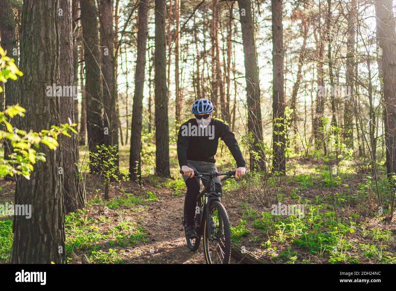 Young man in protective mask from environmental pollution riding mountain  bike on cross country road. Cyclist Riding the Bike on Stock Photo - Alamy