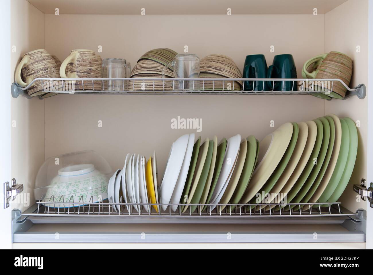 https://c8.alamy.com/comp/2DH27KP/clean-dishes-in-white-and-green-tones-in-a-drying-cabinet-cups-glasses-mugs-plates-bowls-saucers-on-metal-shelves-concept-for-kitchen-interior-2DH27KP.jpg