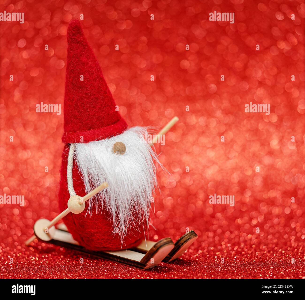 Santa Claus skiing on red blurred bokeh background. Copy space, selective focus. Stock Photo